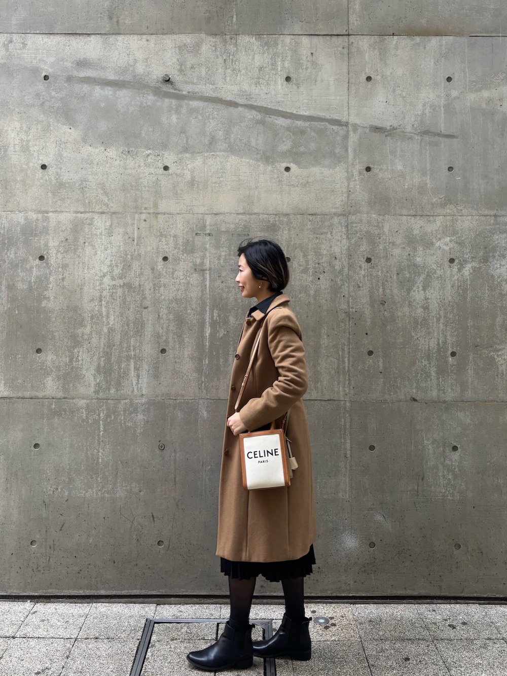 ブラック系のスカート、ブラック系のシャツ/ブラウス、ブラウン系のステンカラーコートを着用したレディースの春コーディネートの3枚目の写真
