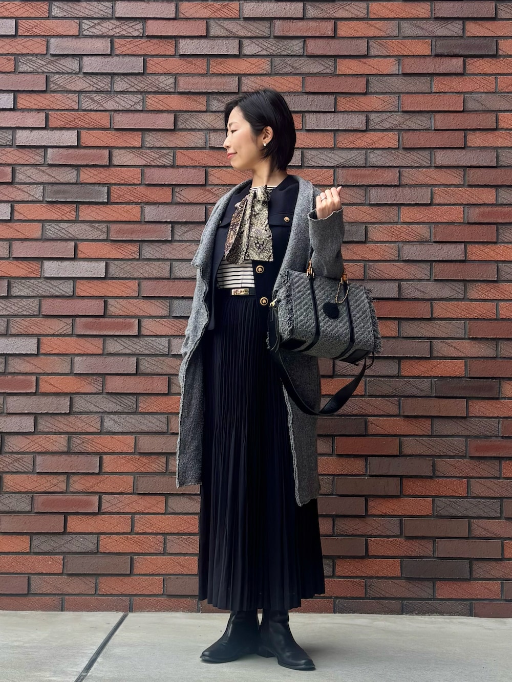 ホワイト系のTシャツ/カットソー、ブラック系のノーカラージャケット、グレー系のその他アウターを着用したレディースの冬コーディネートの2枚目の写真