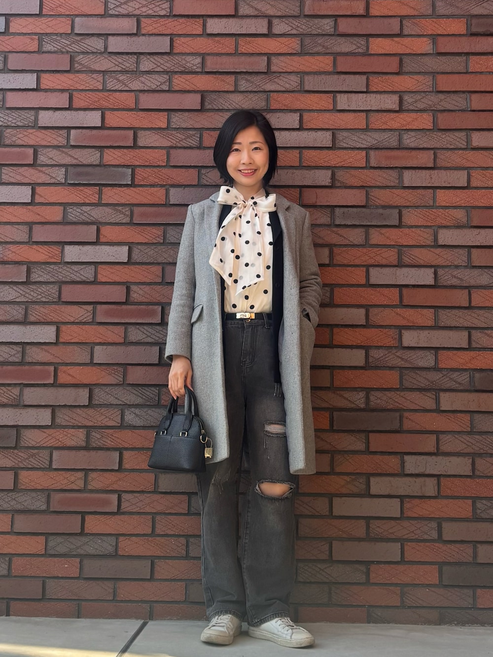 ホワイト系のスニーカー、ホワイト系のシャツ/ブラウス、ブラック系のジャケット/アウターを着用したレディースの春コーディネートの2枚目の写真