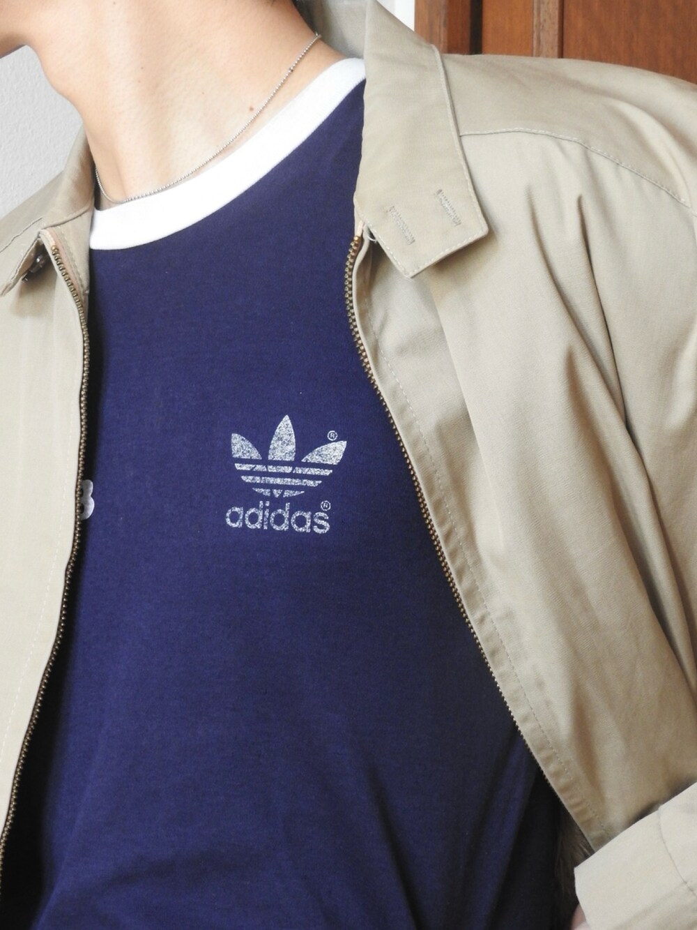 ベージュ系のブルゾン、ブルー系のTシャツ/カットソー、グレー系のスラックスを着用したメンズの春コーディネートの2枚目の写真