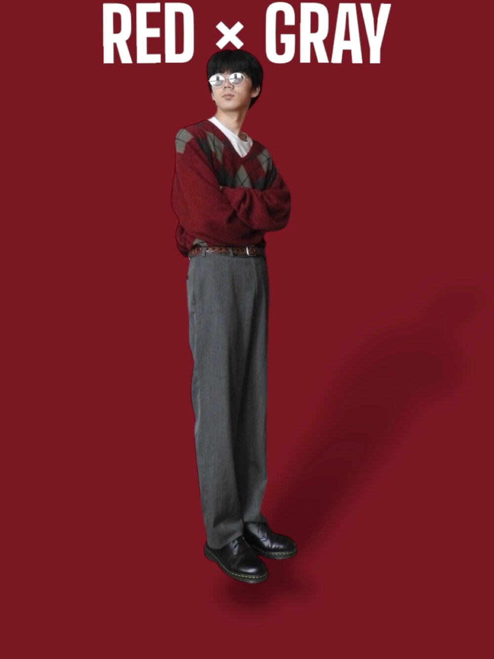 グレー系のスラックス、レッド系のニット/セーター、ブラック系のドレスシューズを着用したメンズの春コーディネートの2枚目の写真