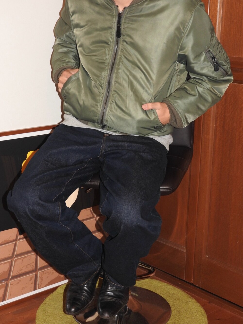 グリーン系のミリタリージャケット、ブルー系のデニムパンツ、ブラック系のドレスシューズを着用したメンズの春コーディネートの2枚目の写真