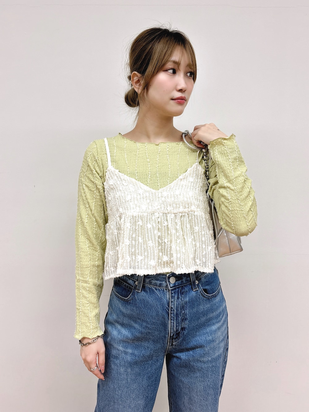グリーン系のTシャツ/カットソー、ホワイト系のキャミソールを着用したレディースの春コーディネートの3枚目の写真