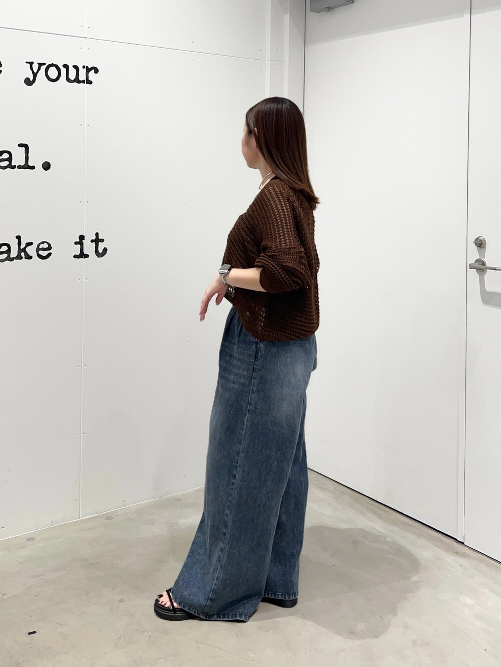 ブルー系のデニムパンツ、ブラック系のショルダーバッグ、ブラウン系のカーディガン/ボレロを着用したレディースの夏コーディネートの2枚目の写真