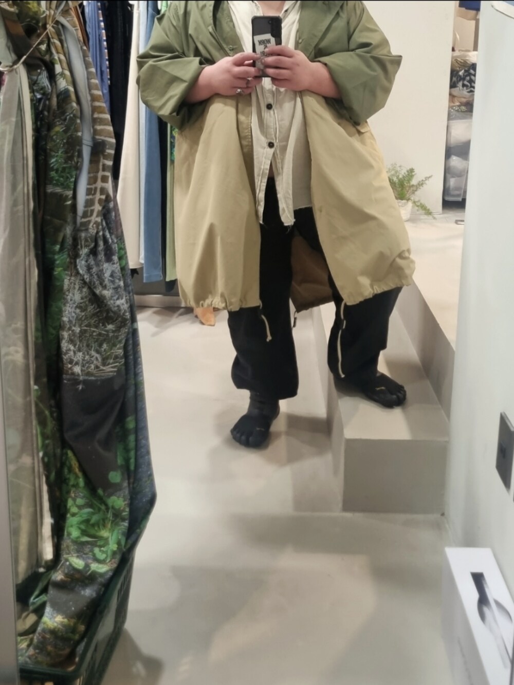 ブラック系のスラックス、ベージュ系のモッズコート、ブラック系のスニーカーを着用したメンズの秋コーディネートの2枚目の写真