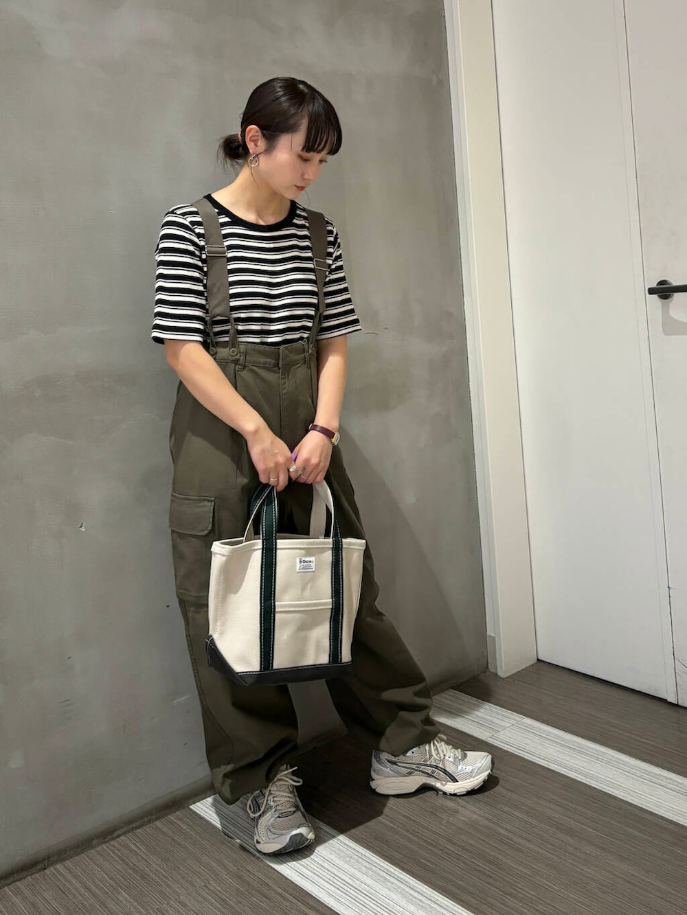 ブラック系のTシャツ/カットソー、グリーン系のカーゴパンツ、ホワイト系のトートバッグを着用したレディースの夏コーディネートの2枚目の写真