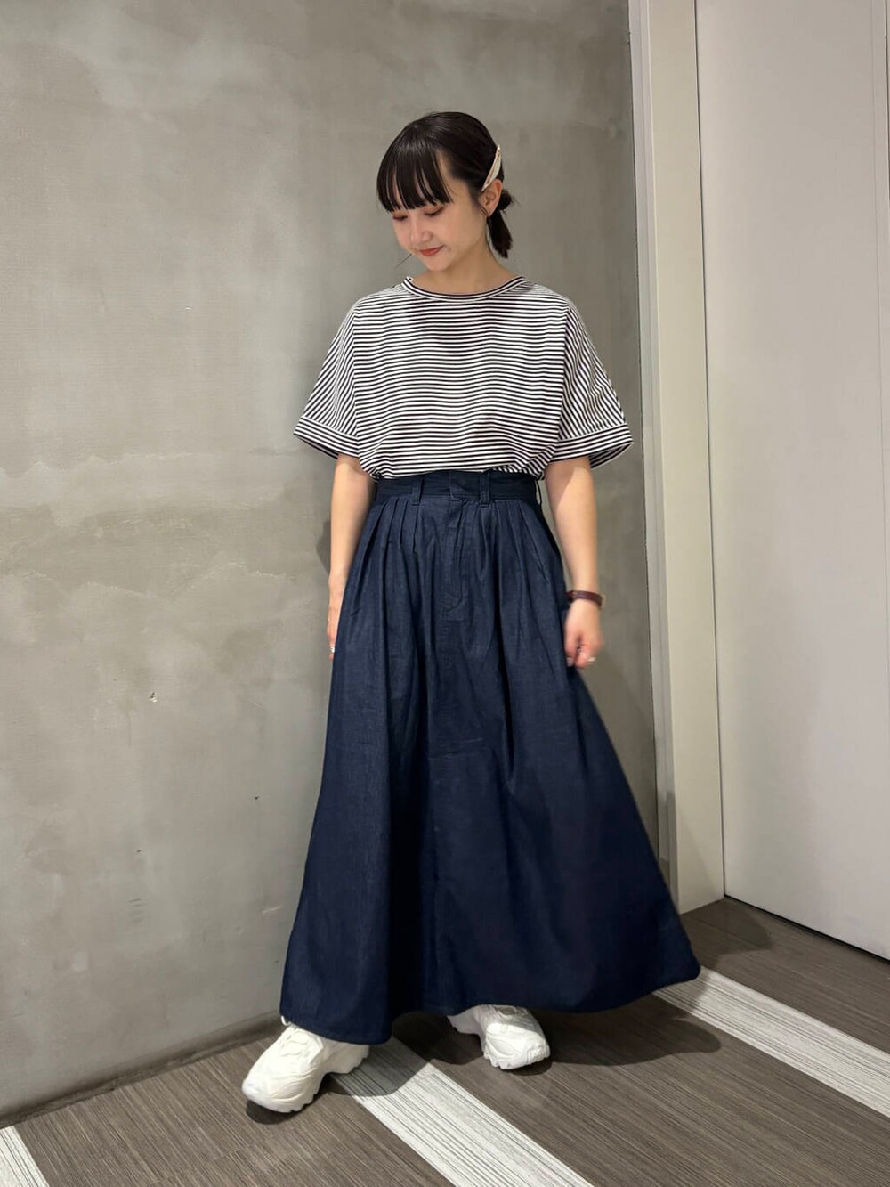 ホワイト系のスニーカー、ホワイト系のTシャツ/カットソー、ブルー系のスカートを着用したレディースの夏コーディネートの2枚目の写真