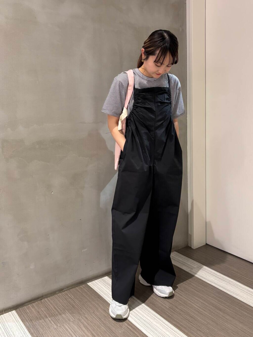 シルバー系のスニーカー、ブラック系のサロペット/オーバーオール、ピンク系のエコバッグ/サブバッグを着用したレディースの春コーディネートの4枚目の写真
