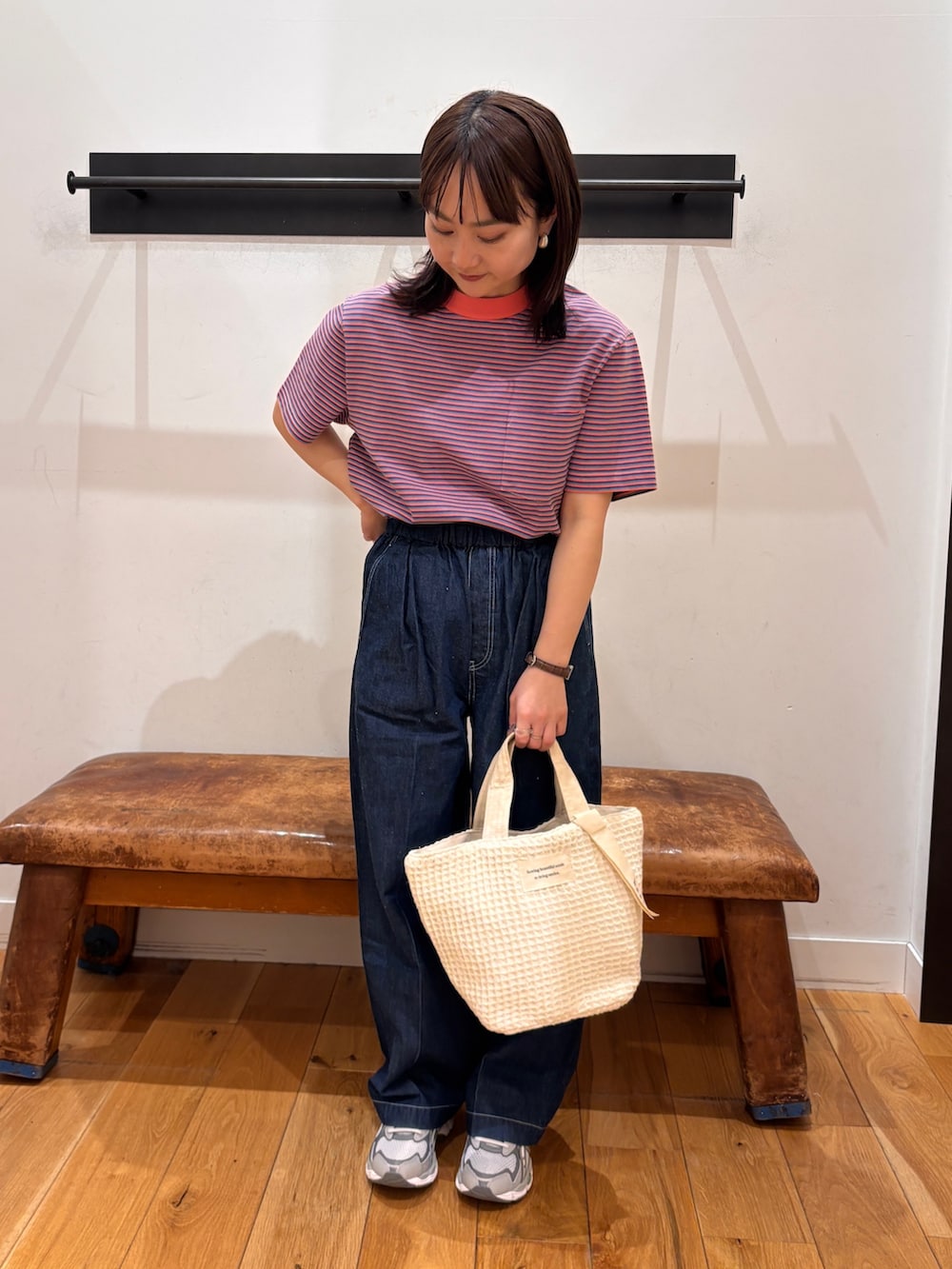 ピンク系のTシャツ/カットソー、ブルー系のデニムパンツ、ホワイト系のトートバッグを着用したレディースの春コーディネートの2枚目の写真