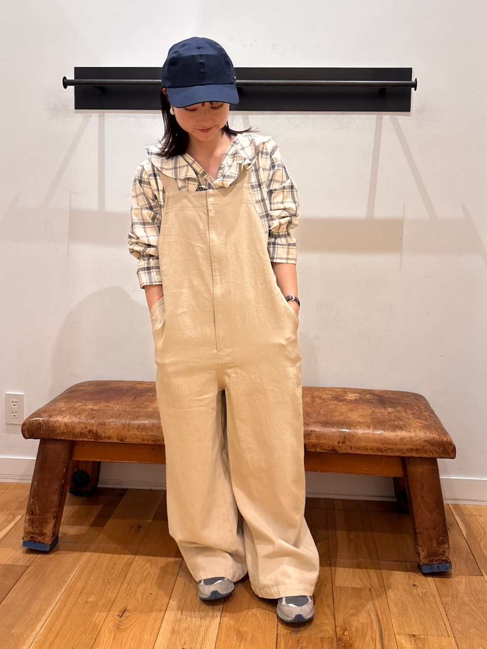 ブラック系のシャツ/ブラウス、ベージュ系のサロペット/オーバーオール、ブルー系のキャップを着用したレディースの春コーディネートの4枚目の写真