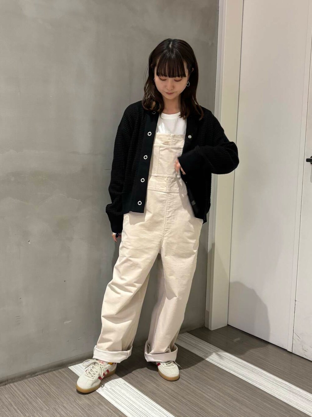 ブラック系のカーディガン/ボレロ、ホワイト系のサロペット/オーバーオール、ホワイト系のTシャツ/カットソーを着用したレディースの秋コーディネートの2枚目の写真