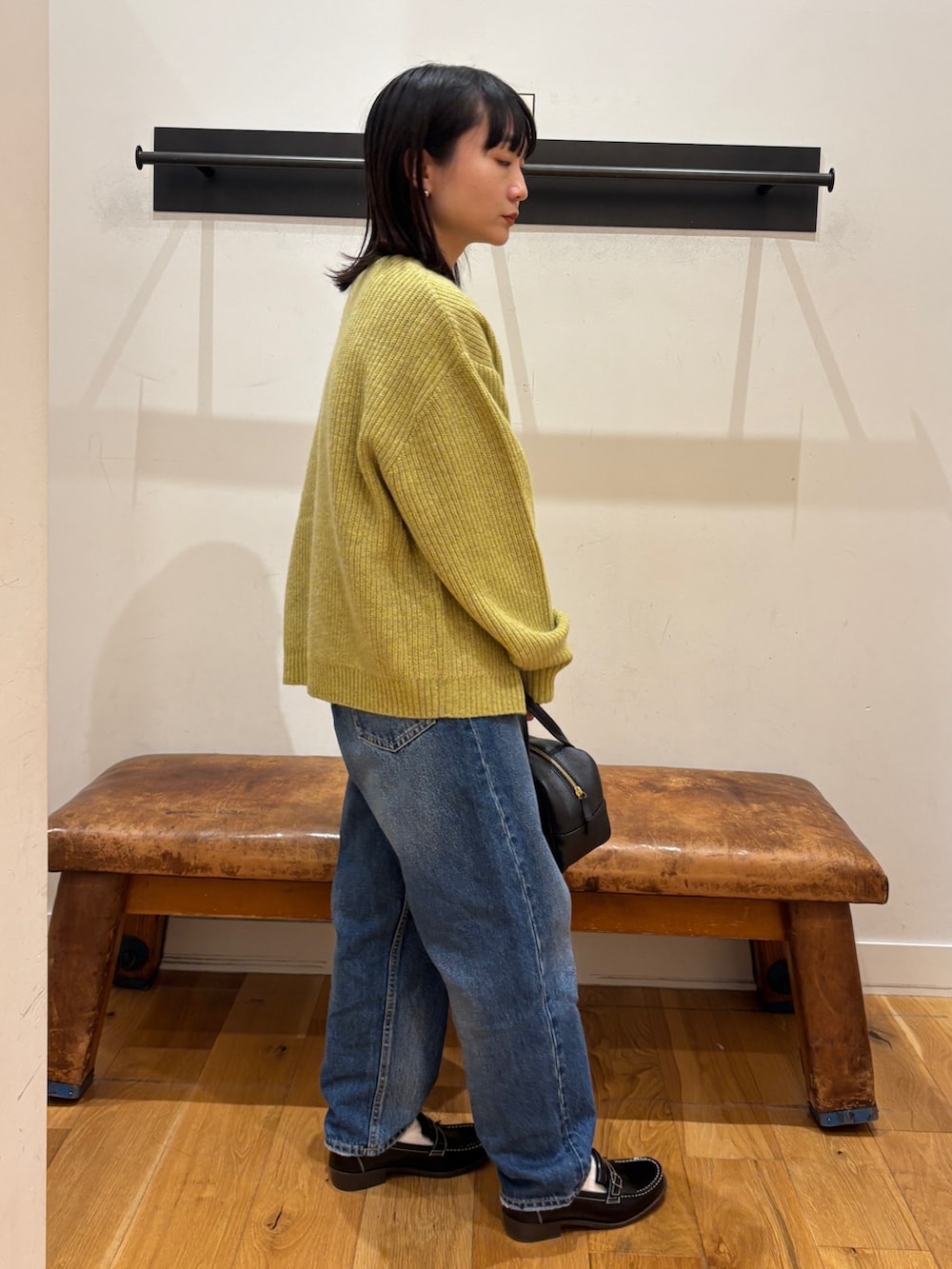 グリーン系のカーディガン/ボレロ、ホワイト系のTシャツ/カットソー、ブラック系のボストンバッグを着用したレディースの秋コーディネートの2枚目の写真