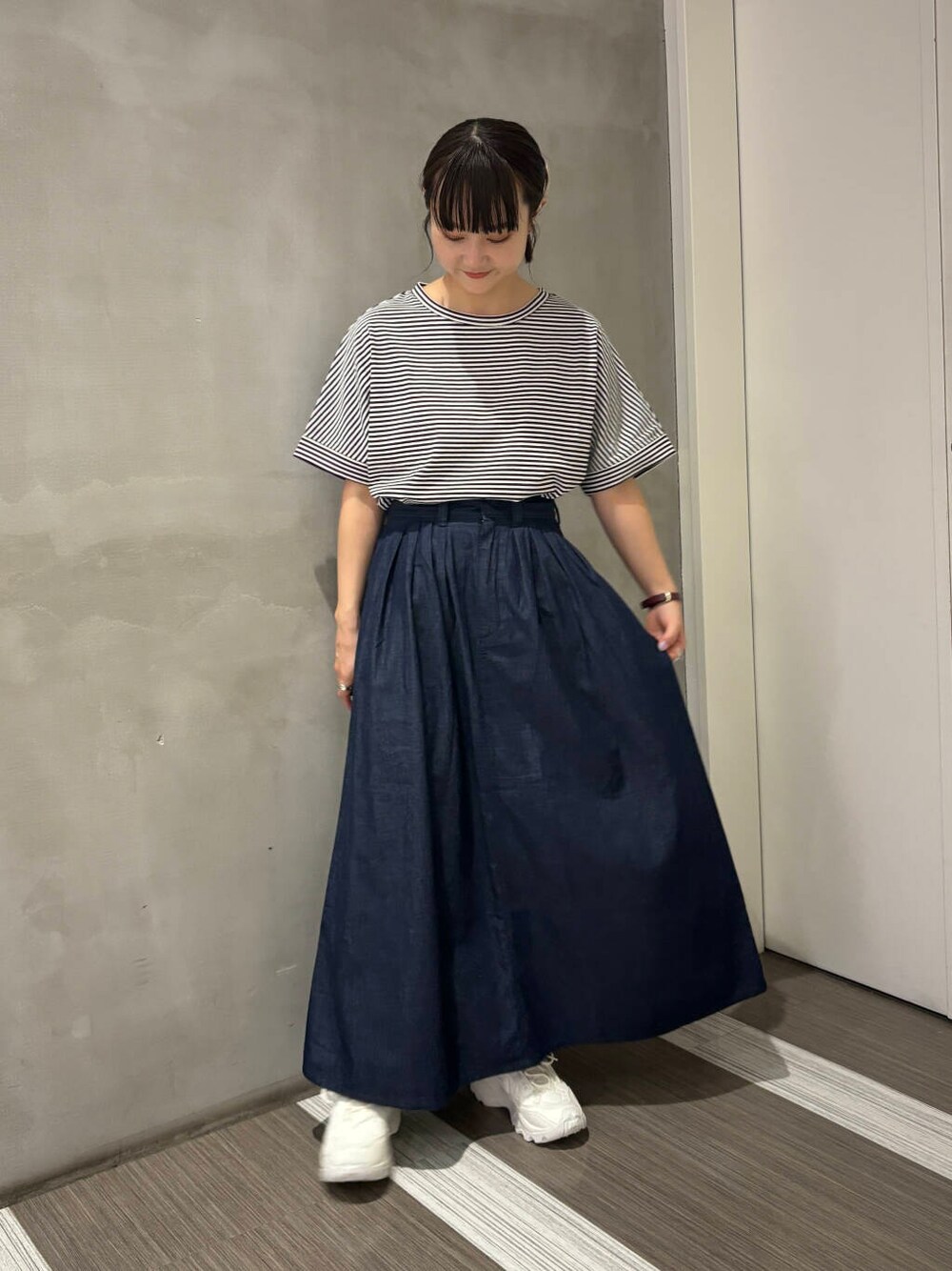 ホワイト系のスニーカー、ホワイト系のTシャツ/カットソー、ブルー系のスカートを着用したレディースの夏コーディネートの5枚目の写真