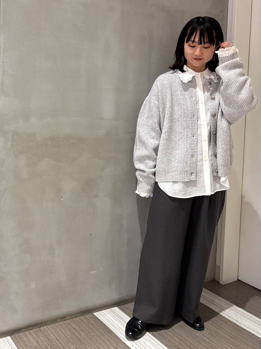 ホワイト系のシャツ/ブラウス、グレー系のカーディガン/ボレロ、グレー系のその他パンツを着用したレディースの秋コーディネートの4枚目の写真
