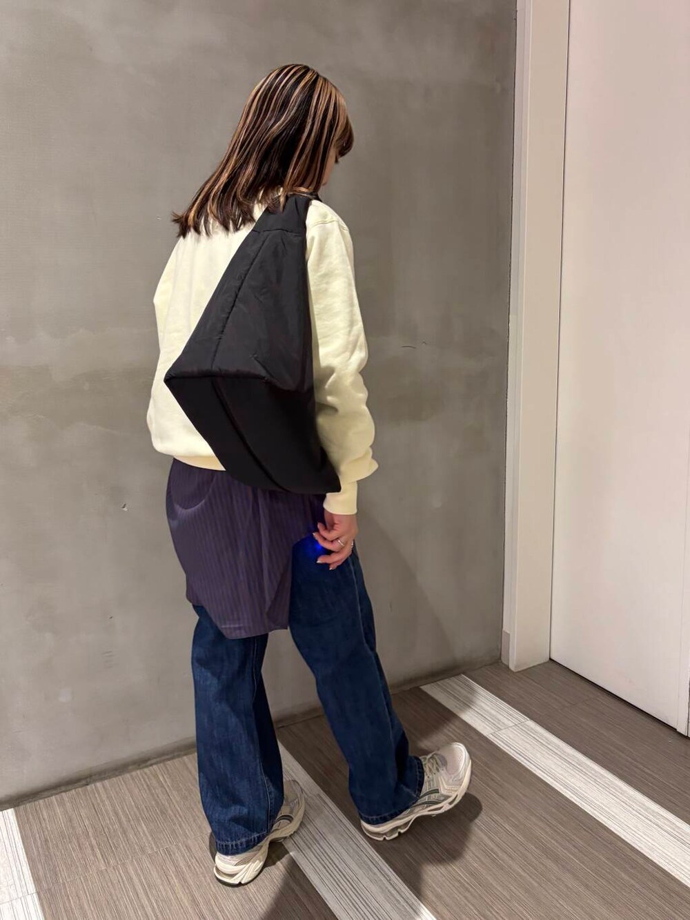 ブルー系のTシャツ/カットソー、ブルー系のデニムパンツ、ブラック系のトートバッグを着用したレディースの冬コーディネートの5枚目の写真