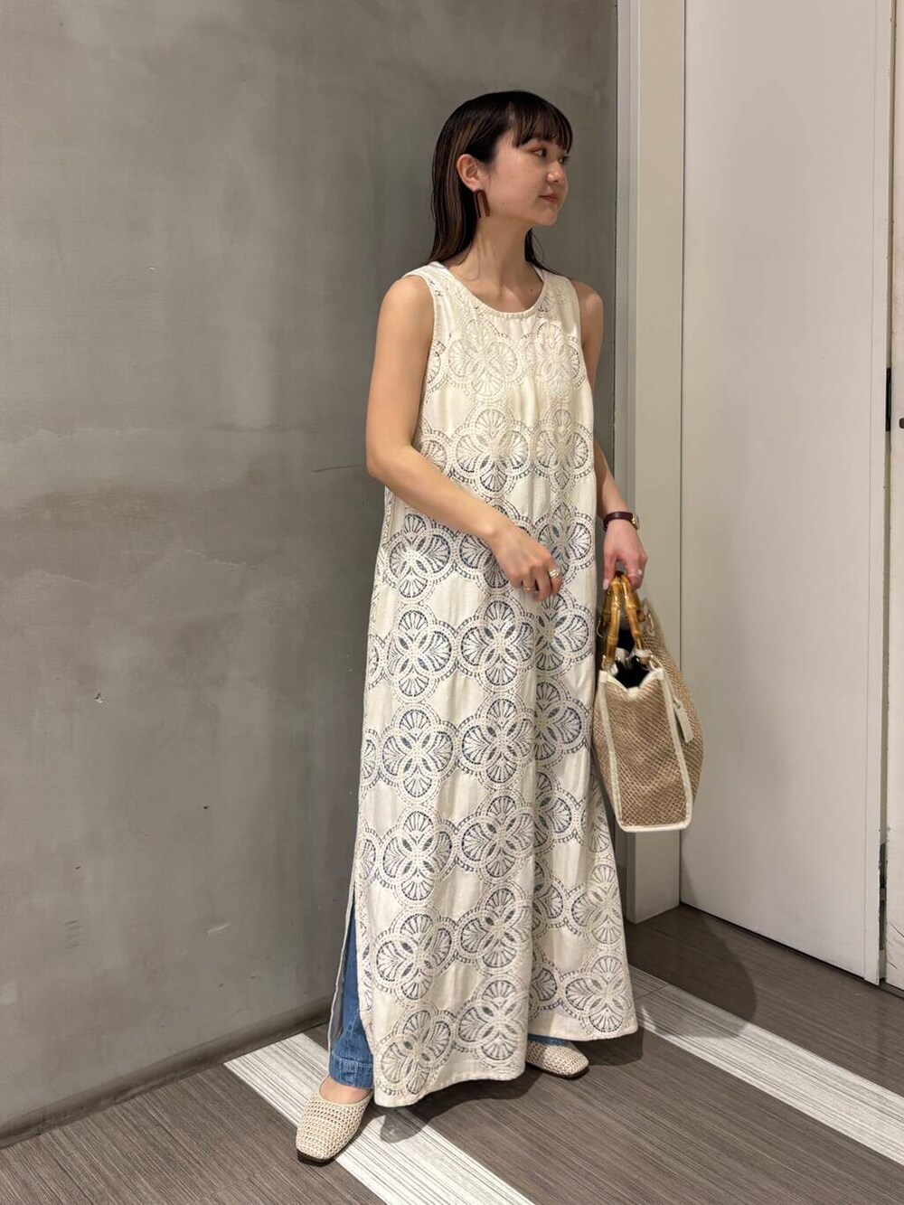 ホワイト系のタンクトップ、ブルー系のデニムパンツ、ホワイト系のバレエシューズを着用したレディースの春コーディネートの6枚目の写真