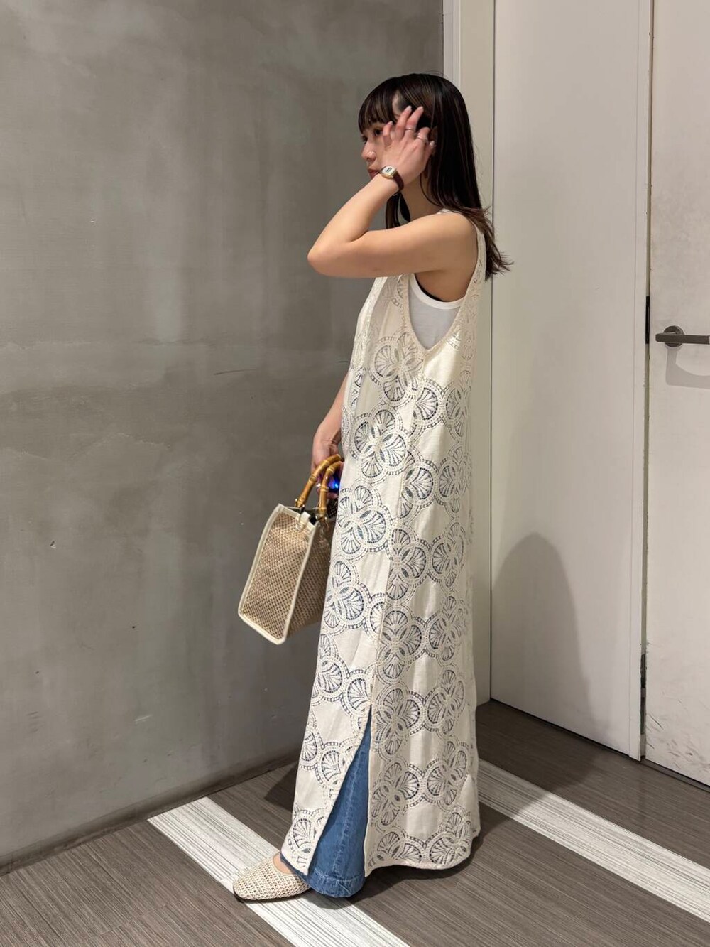 ホワイト系のタンクトップ、ブルー系のデニムパンツ、ホワイト系のバレエシューズを着用したレディースの春コーディネートの4枚目の写真