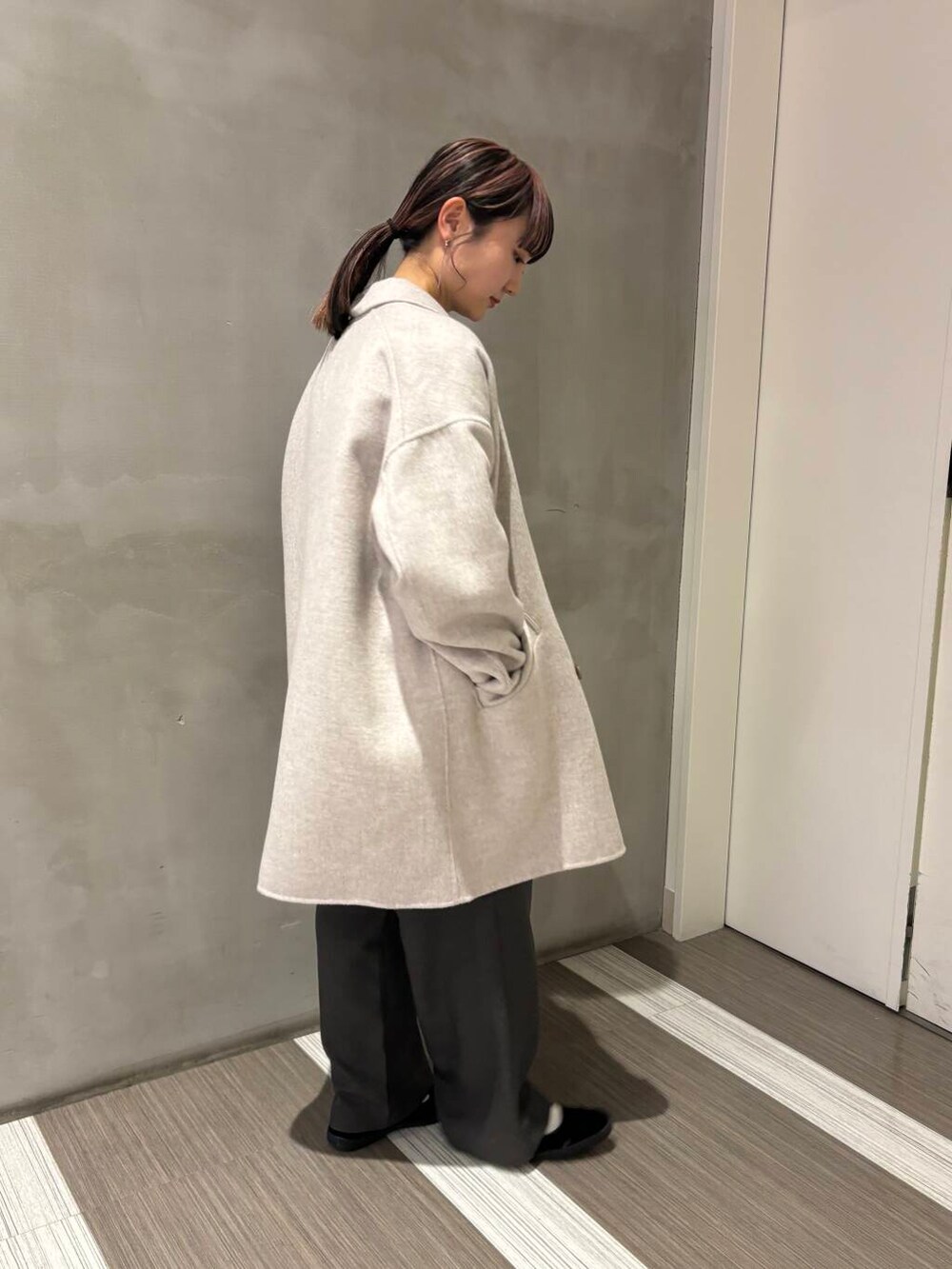 ベージュ系のその他アウター、グリーン系のニット/セーター、グレー系のその他パンツを着用したレディースの秋コーディネートの2枚目の写真