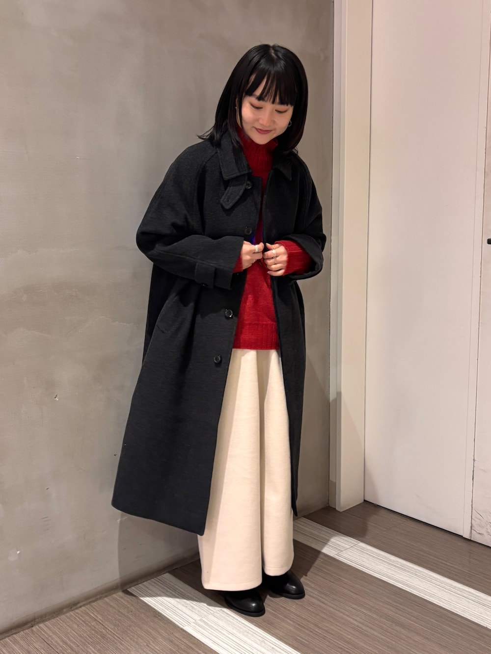 グレー系のその他アウター、レッド系のニット/セーター、ホワイト系のその他パンツを着用したレディースの冬コーディネートの3枚目の写真