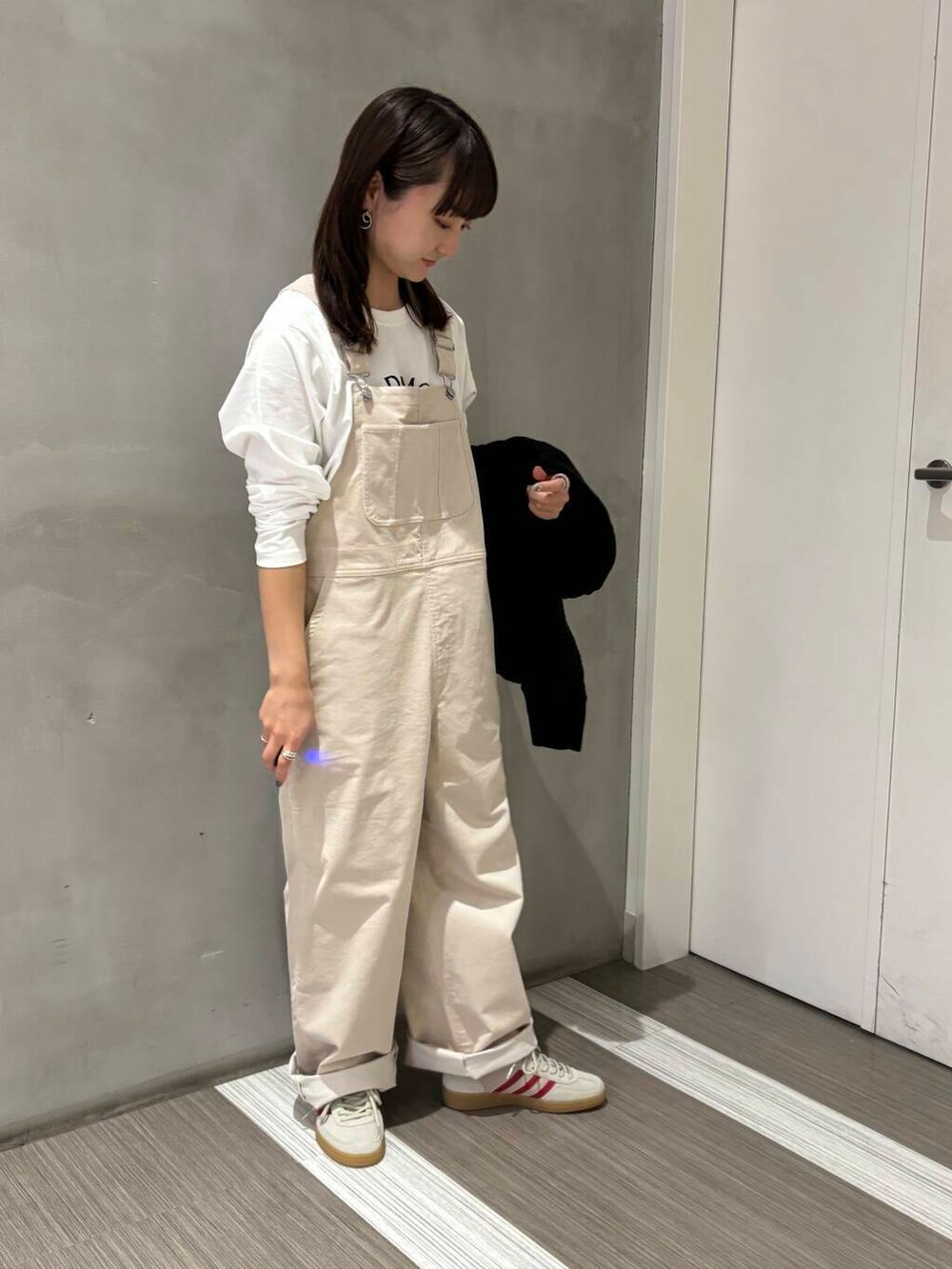 ブラック系のカーディガン/ボレロ、ホワイト系のサロペット/オーバーオール、ホワイト系のTシャツ/カットソーを着用したレディースの秋コーディネートの5枚目の写真