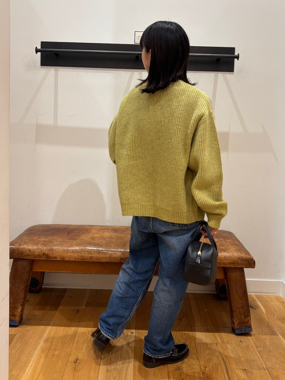 グリーン系のカーディガン/ボレロ、ホワイト系のTシャツ/カットソー、ブラック系のボストンバッグを着用したレディースの秋コーディネートの3枚目の写真