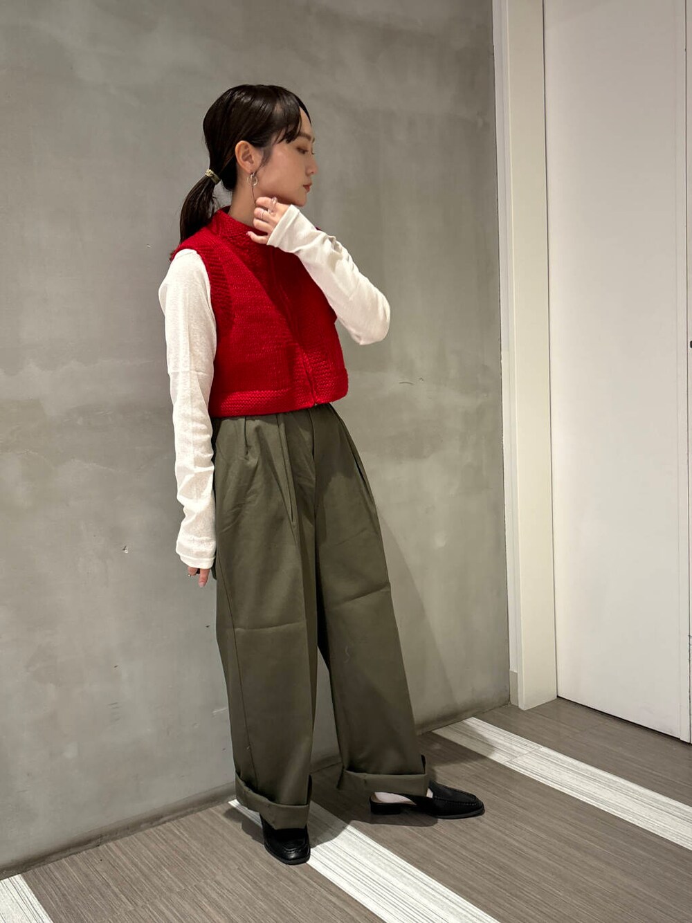 ブラック系のサンダル、ホワイト系のTシャツ/カットソー、グリーン系のチノパンツを着用したレディースの秋コーディネートの4枚目の写真