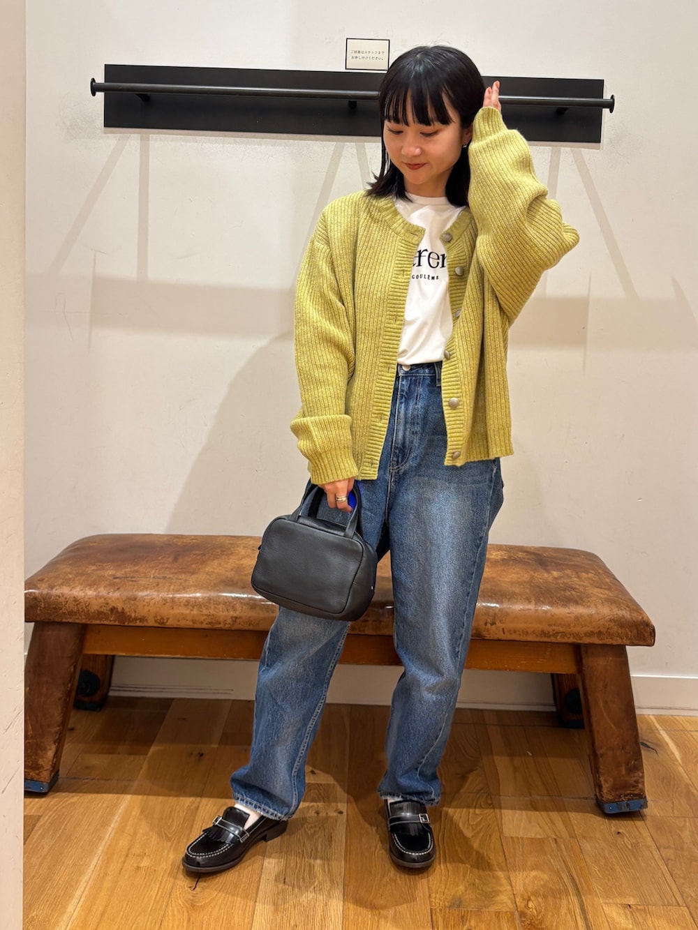 グリーン系のカーディガン/ボレロ、ホワイト系のTシャツ/カットソー、ブラック系のボストンバッグを着用したレディースの秋コーディネートの4枚目の写真