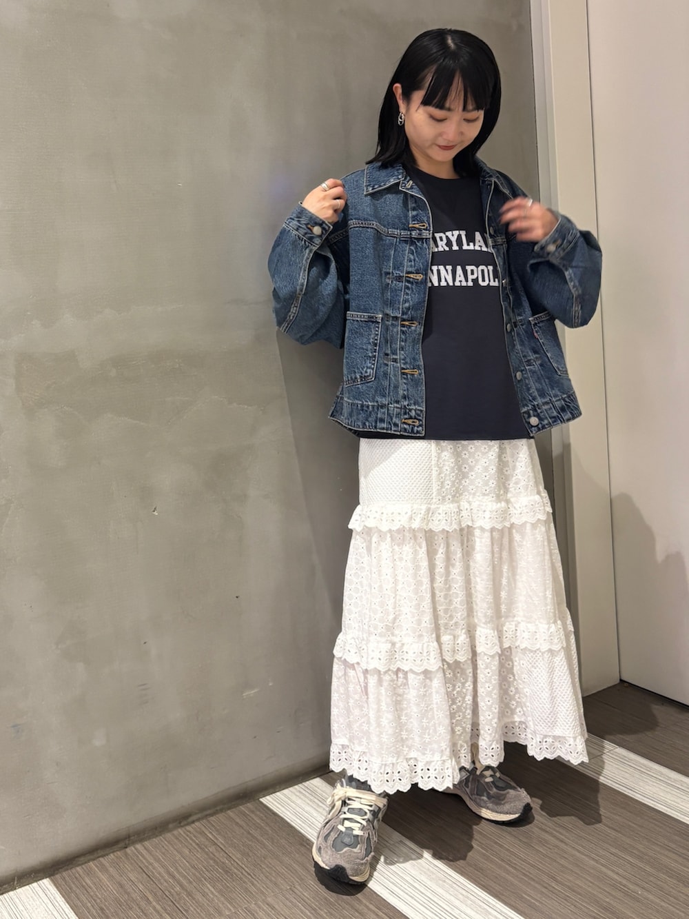 ブルー系のデニムジャケット、グレー系のTシャツ/カットソー、ホワイト系のスカートを着用したレディースの秋コーディネートの2枚目の写真
