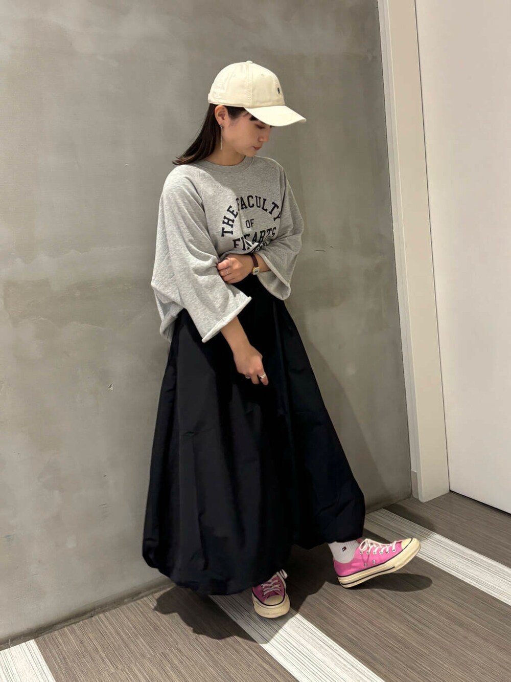 グレー系のTシャツ/カットソー、ブラック系のその他パンツ、ホワイト系のキャップを着用したレディースの秋コーディネートの2枚目の写真