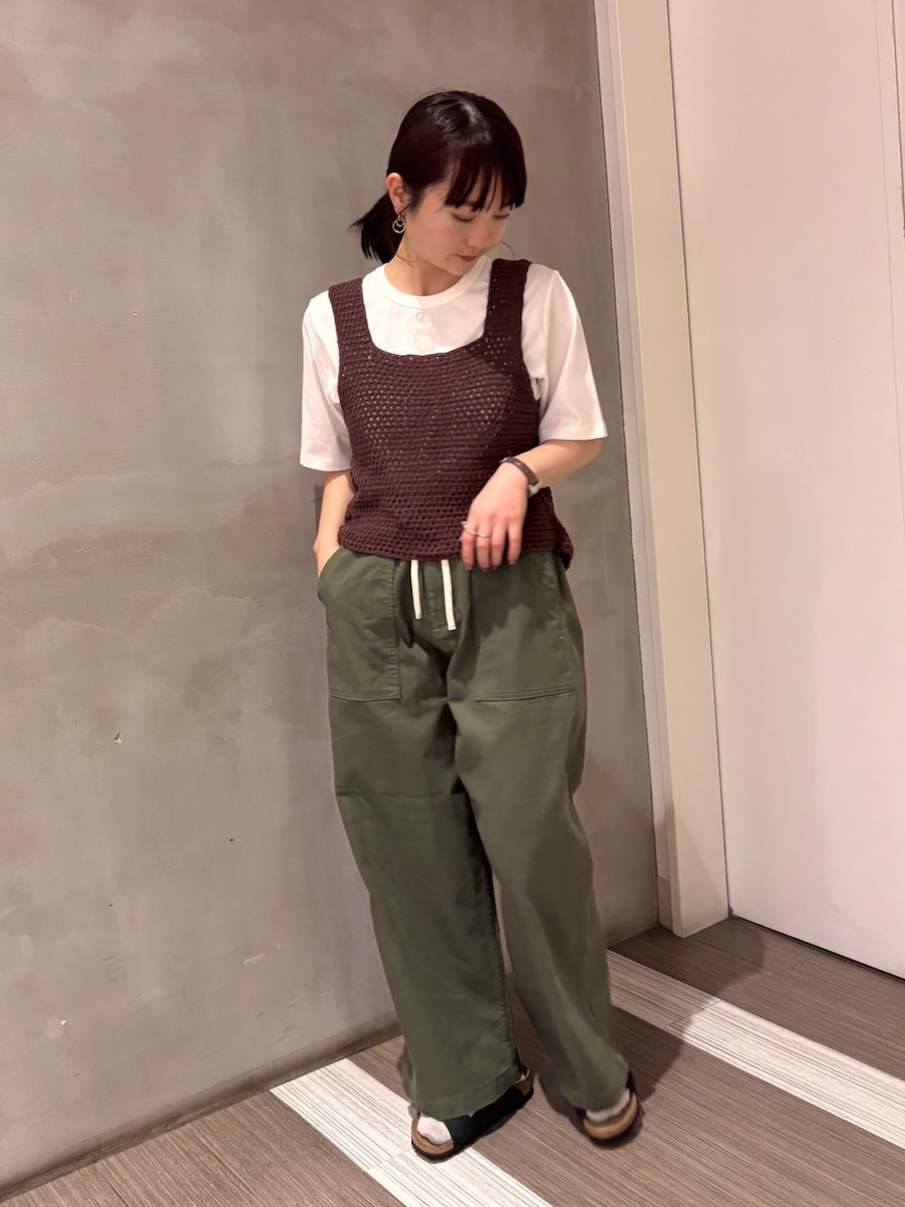 グリーン系のその他パンツ、ブラウン系のタンクトップ、ホワイト系のTシャツ/カットソーを着用したレディースの春コーディネートの5枚目の写真