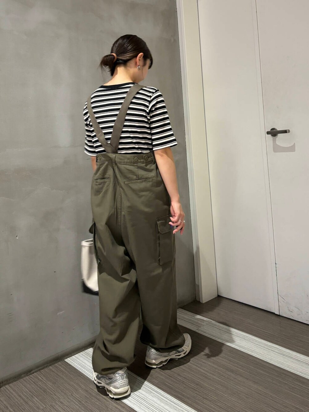 ブラック系のTシャツ/カットソー、グリーン系のカーゴパンツ、ホワイト系のトートバッグを着用したレディースの夏コーディネートの4枚目の写真