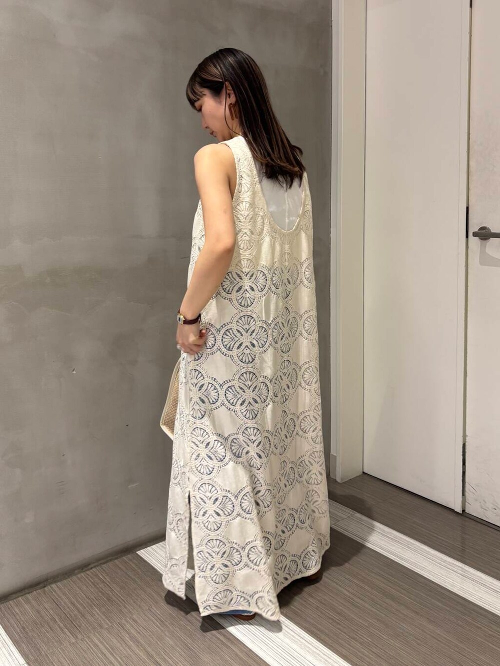 ホワイト系のタンクトップ、ブルー系のデニムパンツ、ホワイト系のバレエシューズを着用したレディースの春コーディネートの5枚目の写真