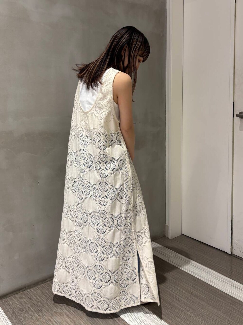 ホワイト系のタンクトップ、ブルー系のデニムパンツ、ホワイト系のバレエシューズを着用したレディースの春コーディネートの3枚目の写真