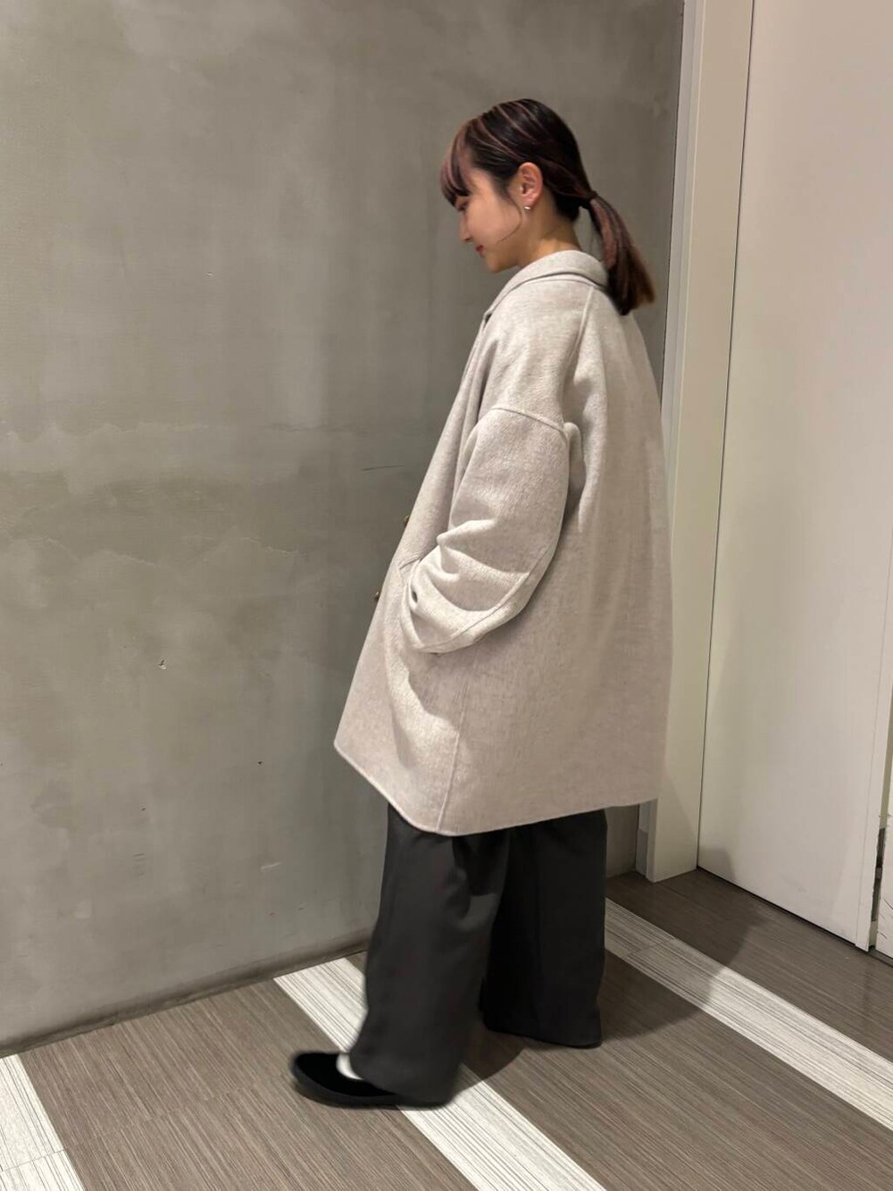 ベージュ系のその他アウター、グリーン系のニット/セーター、グレー系のその他パンツを着用したレディースの秋コーディネートの3枚目の写真