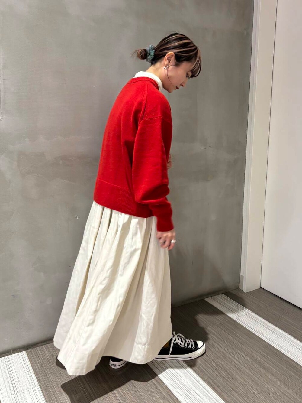 ブラック系のスニーカー、ホワイト系のスカート、レッド系のニット/セーターを着用したレディースの冬コーディネートの4枚目の写真