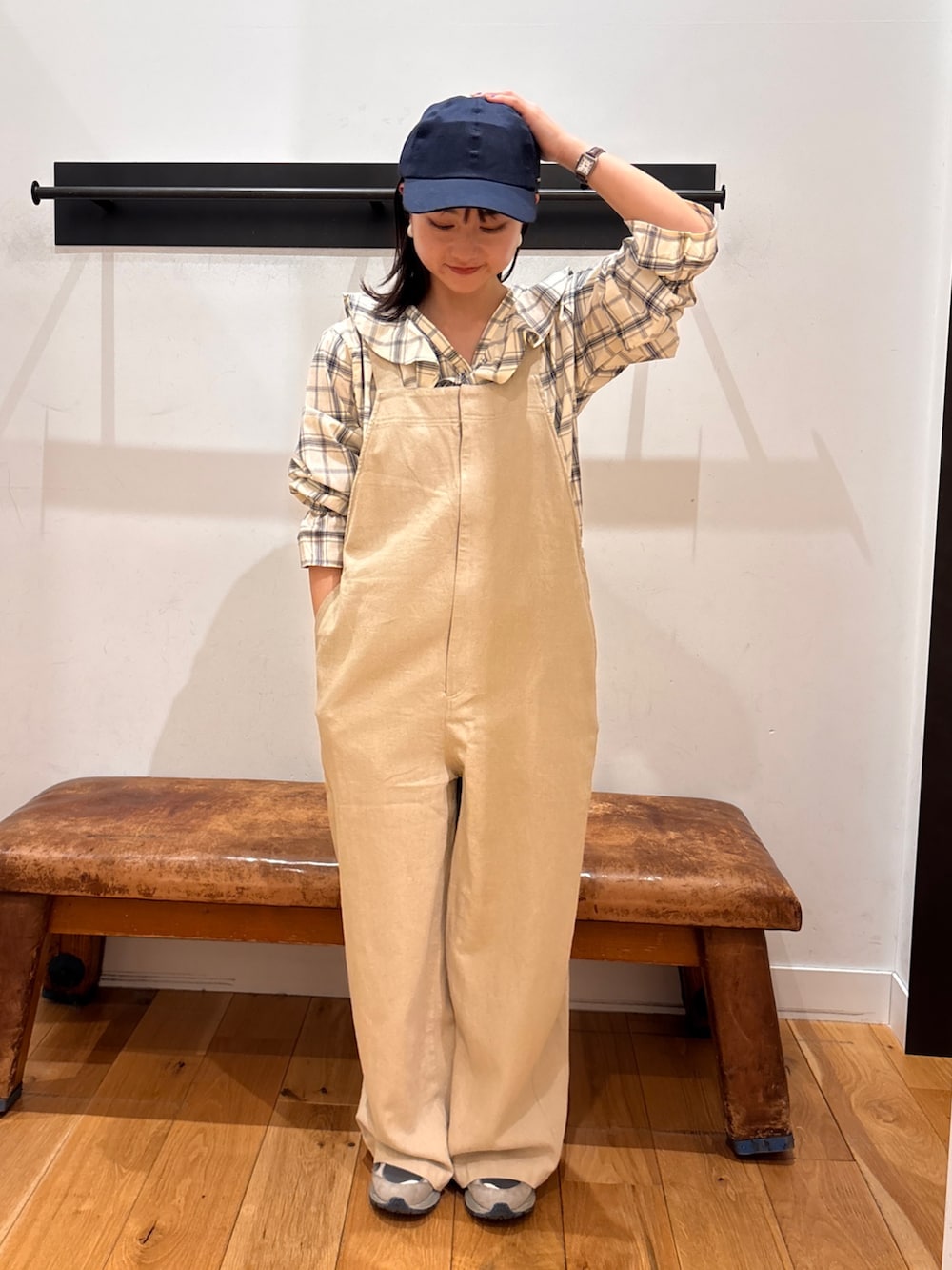 ブラック系のシャツ/ブラウス、ベージュ系のサロペット/オーバーオール、ブルー系のキャップを着用したレディースの春コーディネートの2枚目の写真