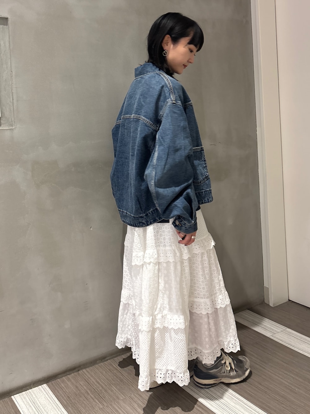 ブルー系のデニムジャケット、グレー系のTシャツ/カットソー、ホワイト系のスカートを着用したレディースの秋コーディネートの5枚目の写真