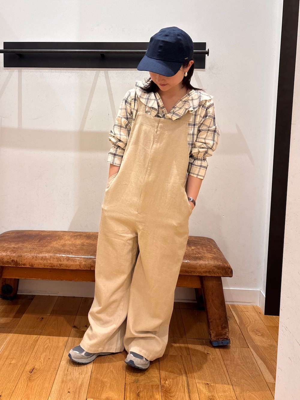 ブラック系のシャツ/ブラウス、ベージュ系のサロペット/オーバーオール、ブルー系のキャップを着用したレディースの春コーディネートの3枚目の写真