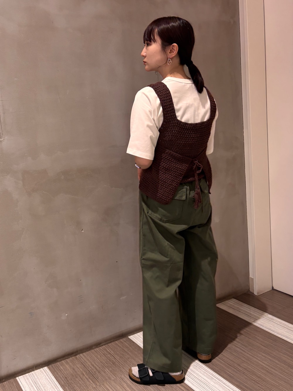 グリーン系のその他パンツ、ブラウン系のタンクトップ、ホワイト系のTシャツ/カットソーを着用したレディースの春コーディネートの3枚目の写真