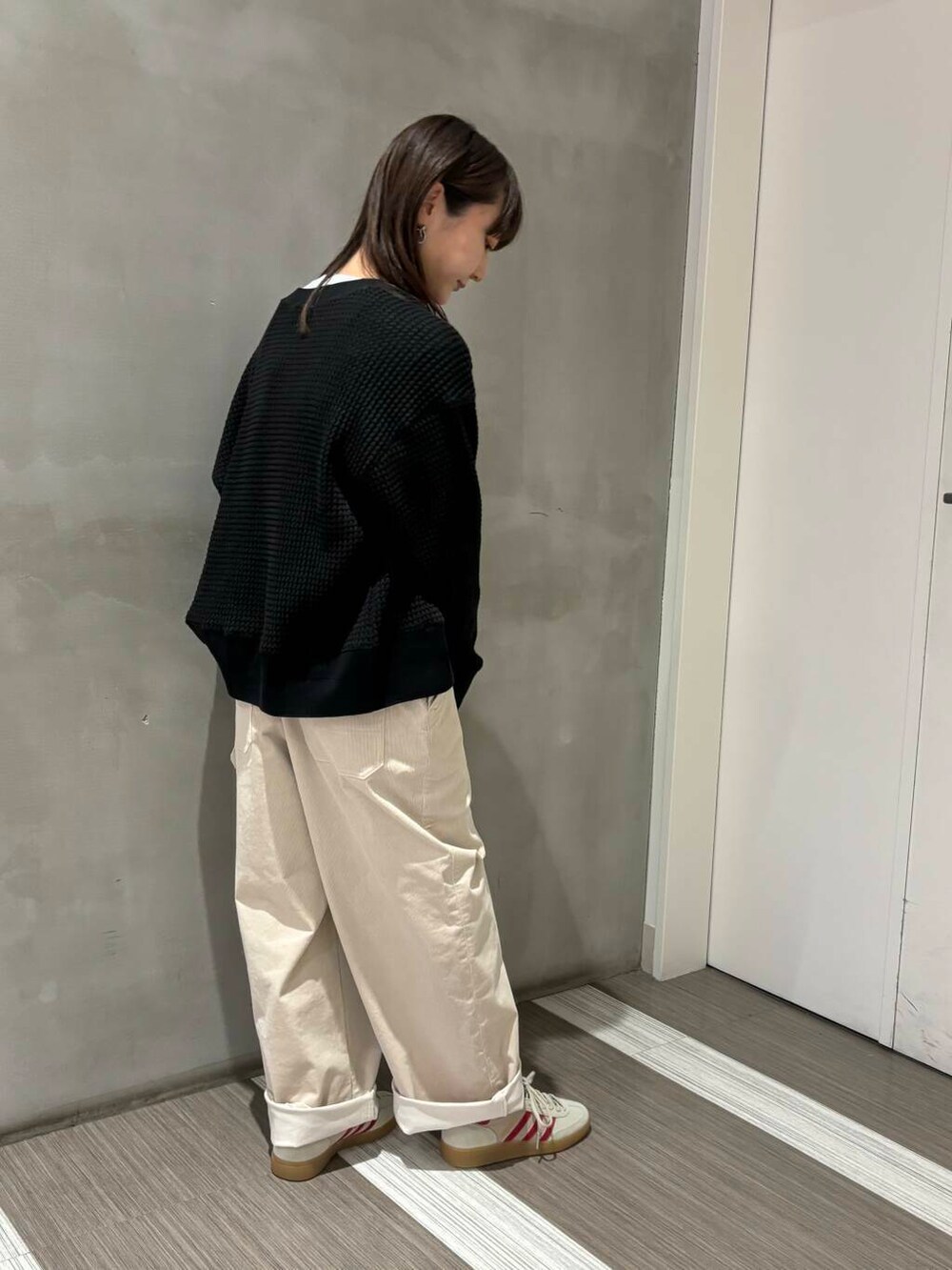 ブラック系のカーディガン/ボレロ、ホワイト系のサロペット/オーバーオール、ホワイト系のTシャツ/カットソーを着用したレディースの秋コーディネートの3枚目の写真