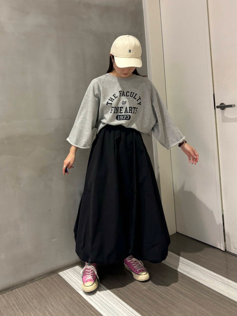 グレー系のTシャツ/カットソー、ブラック系のその他パンツ、ホワイト系のキャップを着用したレディースの秋コーディネートの8枚目の写真
