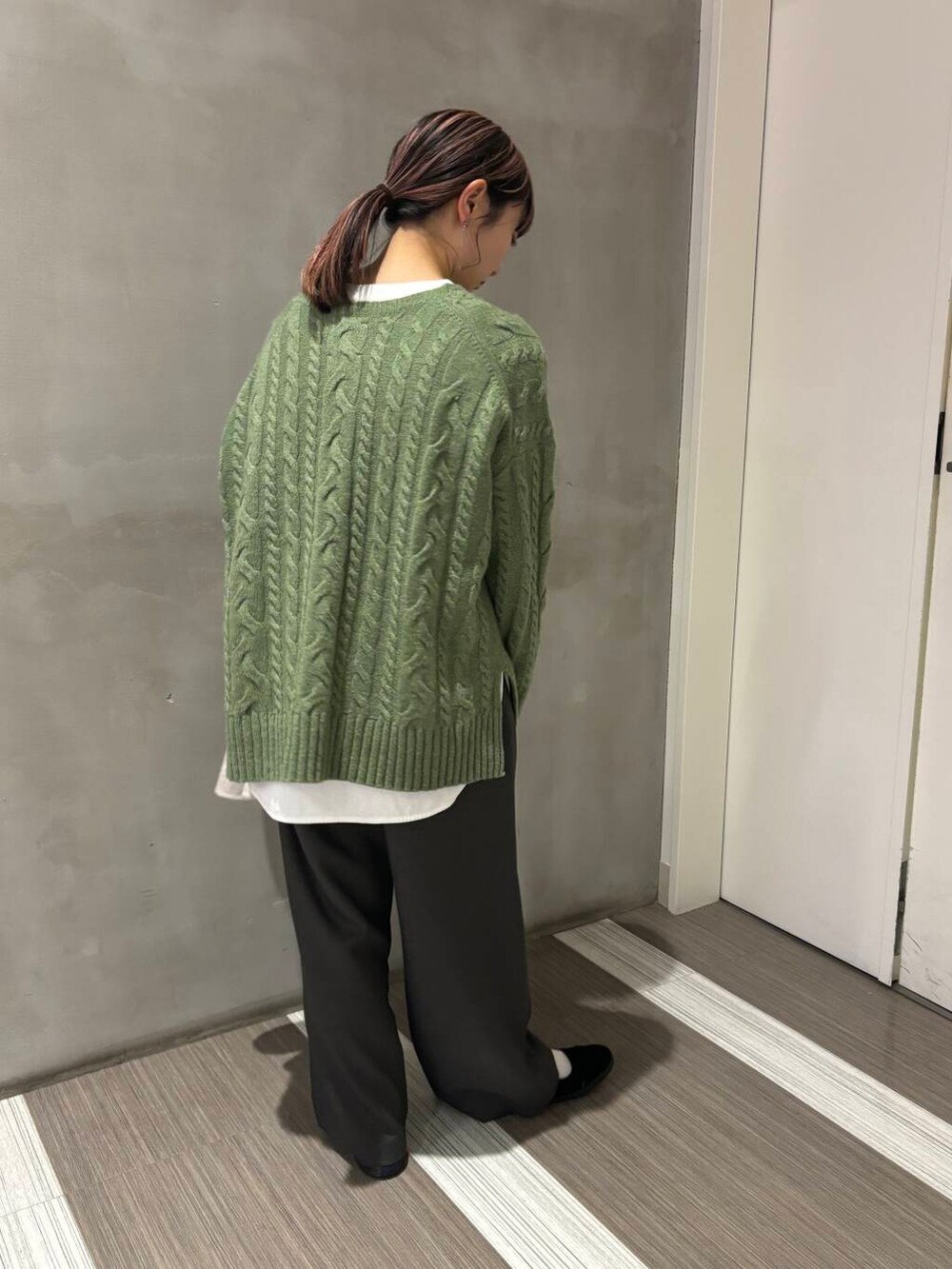 ベージュ系のその他アウター、グリーン系のニット/セーター、グレー系のその他パンツを着用したレディースの秋コーディネートの5枚目の写真