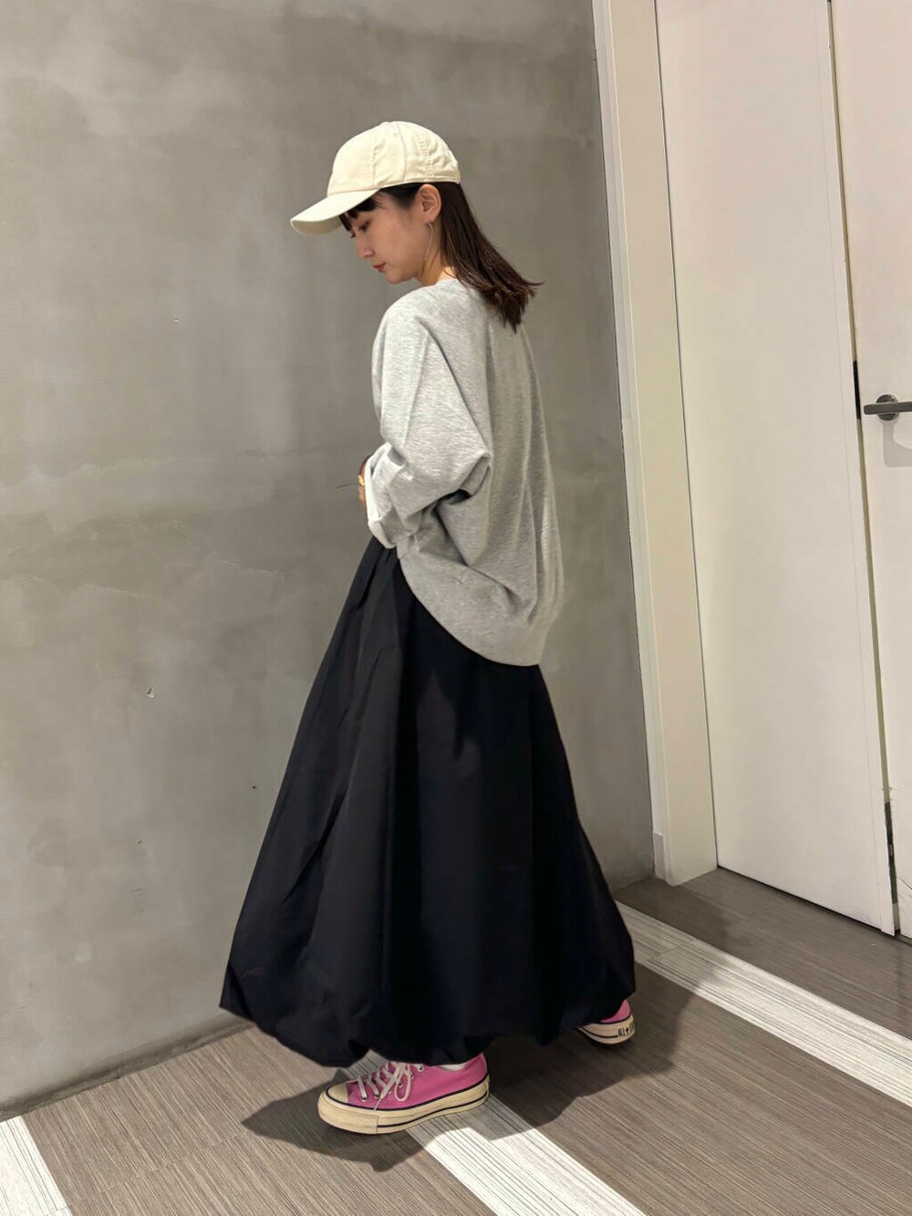 グレー系のTシャツ/カットソー、ブラック系のその他パンツ、ホワイト系のキャップを着用したレディースの秋コーディネートの4枚目の写真
