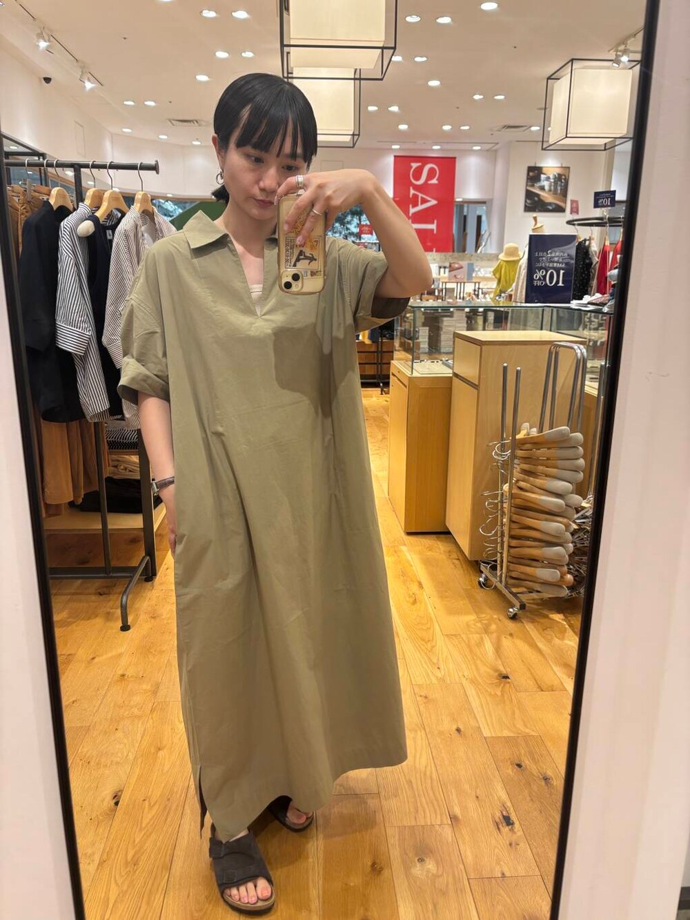 グレー系のサンダル、ベージュ系のワンピースを着用したレディースの夏コーディネートの3枚目の写真