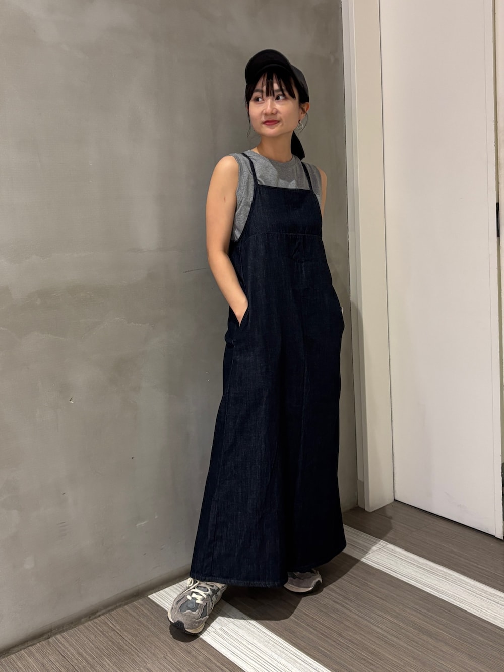 ブルー系のワンピース、グレー系のTシャツ/カットソー、グレー系のキャップを着用したレディースの夏コーディネートの2枚目の写真