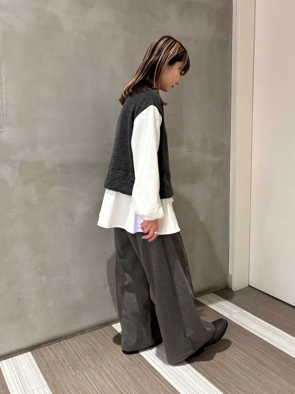 グレー系のブーツ、グレー系のその他パンツ、グレー系のTシャツ/カットソーを着用したレディースの冬コーディネートの4枚目の写真