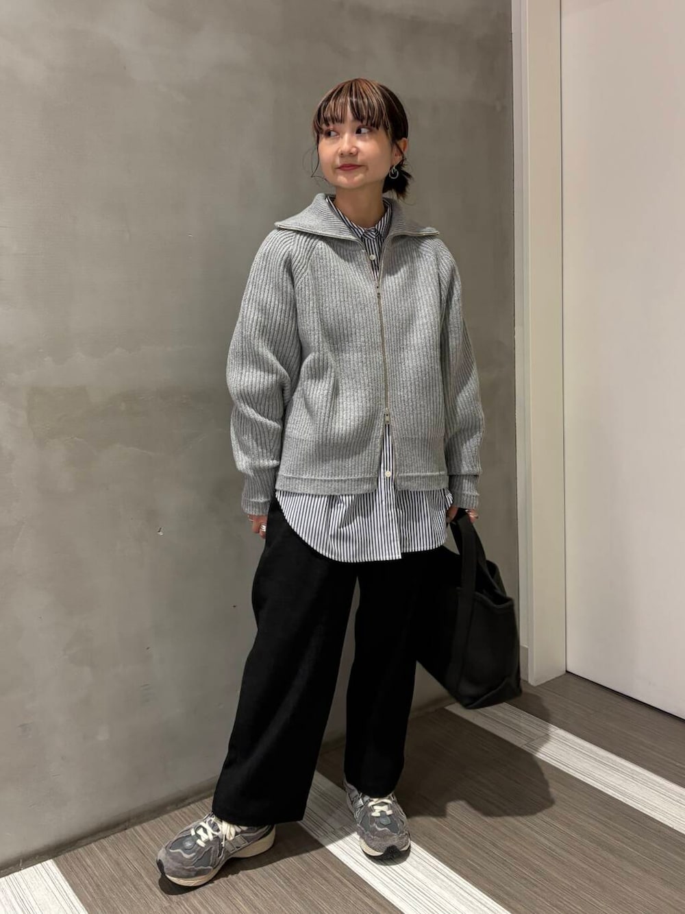 ブルー系のシャツ/ブラウス、グレー系のトートバッグ、グレー系のカーディガン/ボレロを着用したレディースの秋コーディネートの2枚目の写真