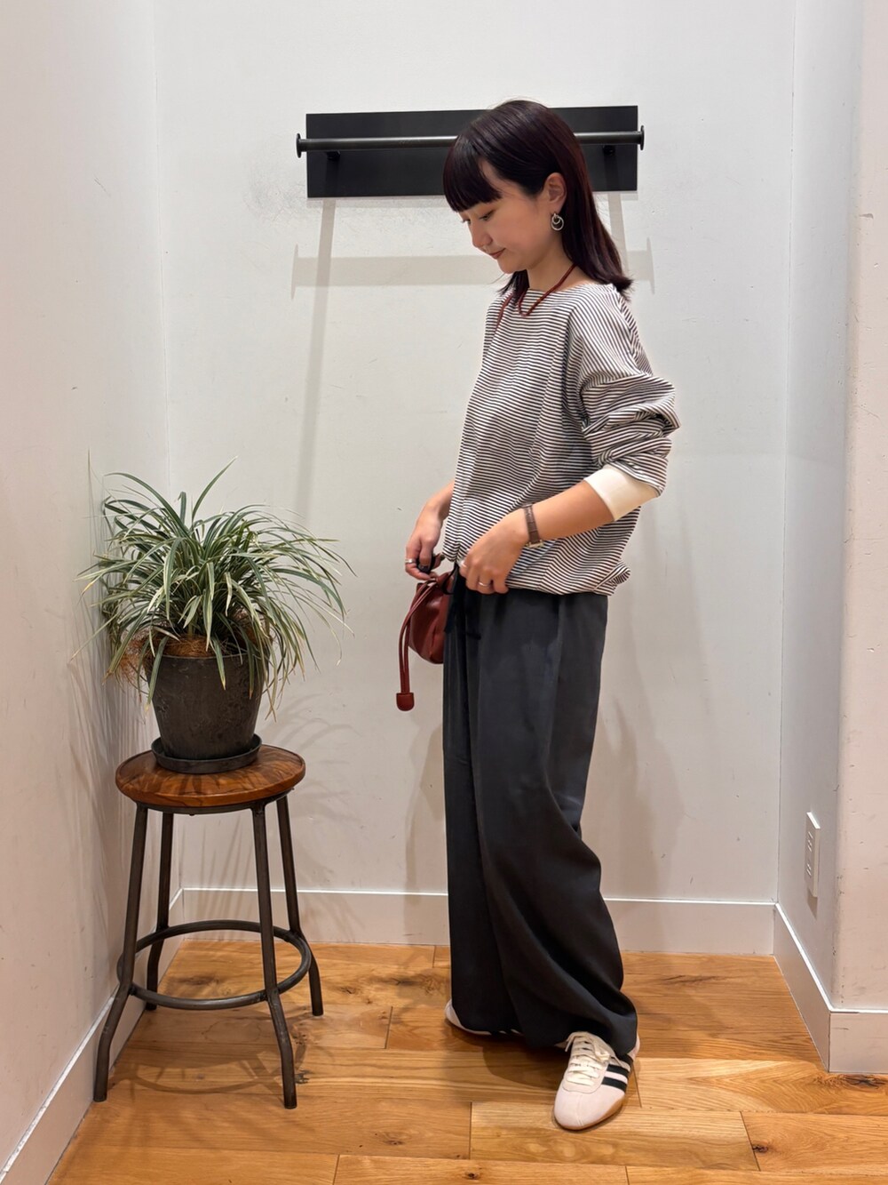 ホワイト系のTシャツ/カットソー、グレー系のその他パンツ、レッド系のショルダーバッグを着用したレディースの秋コーディネートの5枚目の写真