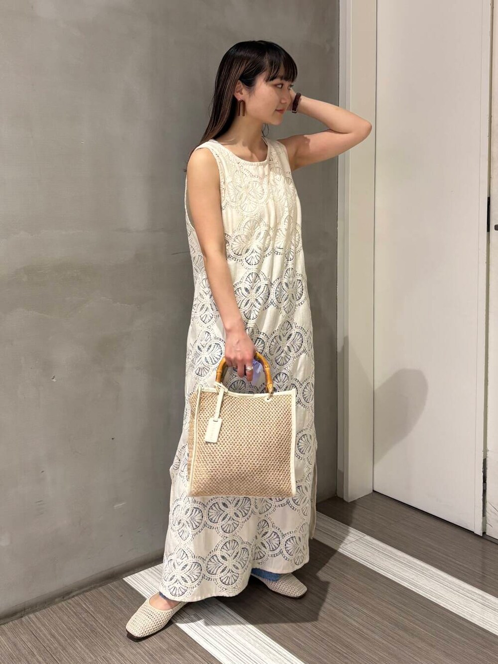 ホワイト系のタンクトップ、ブルー系のデニムパンツ、ホワイト系のバレエシューズを着用したレディースの春コーディネートの2枚目の写真