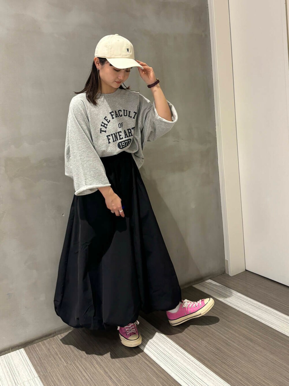 グレー系のTシャツ/カットソー、ブラック系のその他パンツ、ホワイト系のキャップを着用したレディースの秋コーディネートの5枚目の写真
